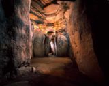 Newgrange passageway with triple spiral engraved on left.