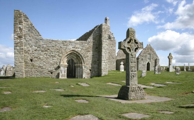 La Cruz de las Escrituras detrás el Arco de los Susurros · heritageireland.ie Monasterio de Clonmacnoise