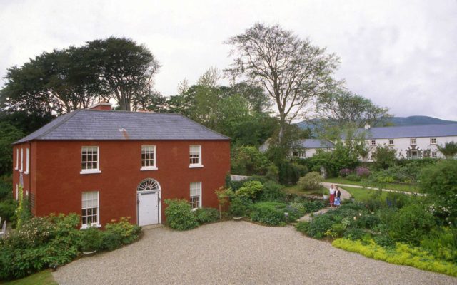 Front façade of Glebe House with planting near the entrance and the Glebe Gallery in the background