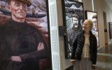 A woman looking at a painting of one of the Great Blasket Islanders