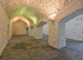 the basement, with the walls painted white, and arches set within the walls