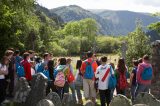 A tour group of young people and teenagers being shown around glendalough monastic site and cemetary by tour guide