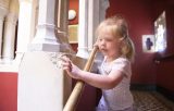 a young girl is interacting with the building she is visiting