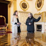 A young woman talking to a tour guide at the luxurious State Rooms at Dublin Castle