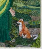 A close-up view of a detailed patchwork quilt. In the centre is a fox sits in a verdant patchwork green setting. On the left we see the edge of St Brigid's emerald green skirt and chartreuse and fern-green cloak. Her arms are outstretched downwards towards the fox who gazes calmly at her.