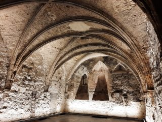 This chapter house within the medieval abbey contains a low vaulted ceiling and the room is lit in artificial light