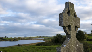 A zoom in on a celtic cross overlooking the Lough