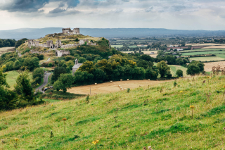 A long shot of the castle with Dunamase in the background, and green fields, as far as the eye can see