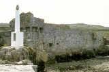 A stone wall of a castle overlooking the beach