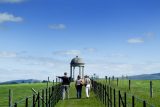 A gazebo in Altamont Gardens. A long path leads to the gazebo at the centre. Three people walk along the path.