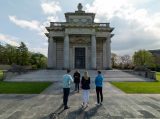 3 people receiving a guided tour with the exterior of Casino Marino as the backdrop behind the guide