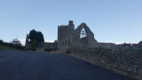 The ruins of a friary backdropped by the dusky sky