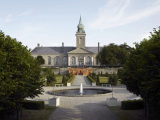 An exterior image of the Rotl Hospital Kilmainham. A fountain sits in the centre of the image in the middle of the formal gardens.