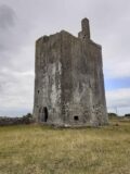 an abandoned stone castle, foreboding in a field