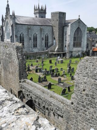 looking into the graveyard of Buttevant Friary, with the modern church just beside it