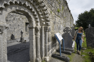 A woman reads the interpretive signage within the ruins of the monastic site