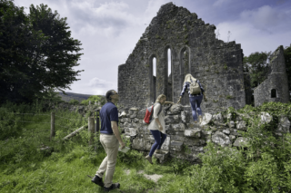 3 people enter the steps into the monastic site