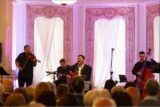 The interior of Farmleigh House. A band plays onstage with purple lighting surrounding them.