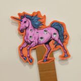 A decorated purple unicorn on a stick