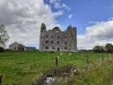 Front view of a ruined castle in a surrounding field