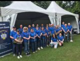 The Lucan Concert band holding their instruments in front of a white marquee