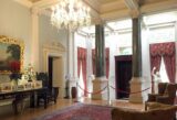 Entrance of Farmleigh House & Estate. a lush rug, paintings and marble columns greet visitors as they enter the building.