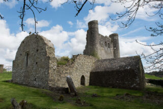 View of the ruins of Dunmoe Castle, backdropped by a blue sky with clouds