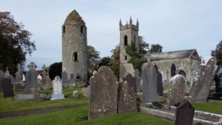 the round tower and church within the graveyard