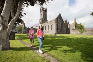 two women exploring the outside of Ennis Friary