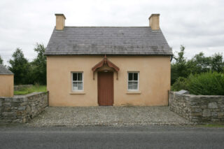 Front elevation of a cottage, painted a warm yellow colour