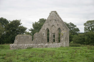 glassless ruins of the church window, with open area of what likely held 3 stained-glass windows