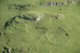 aerial view of the outlines of two ringforts within a green field