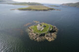 aerial view of Church island in the middle of the sea, the monuments just about visible from the distant vantage point