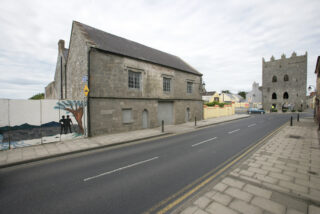 long view of street in front of the stone house, looking towards King John's Castle