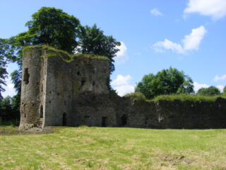 a side profile of the stone castle, with green moss growing along the top of the building