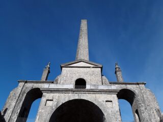 a view looking up at conolly folly, backdropped by the blue sky