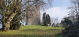 trees conceal the view of the stone castle slightly