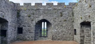 the interior wall of the castle that has a window area looking out over the surrounding landscape