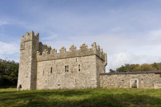 exterior view of the castle, complete with a taller tower on one end, and the attached body of the castle, which is a long rectangular shape.