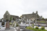 the abbey ruins in image background, with many graves in the surrounding foreground