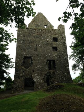 exterior view of the front of Dunmore Castle with the leaves of trees framing the castle