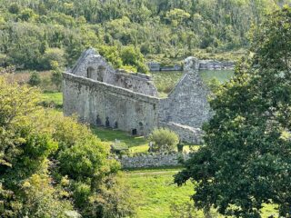 a view of the stone abbey through the trees