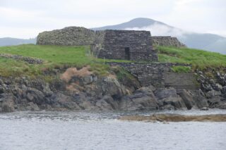 looking at one of the stone huts on approach to the island from the sea