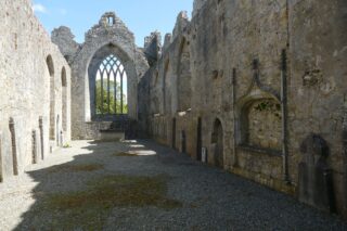 an internal view of the friary ruins, with the intricate, glassless window at one end.