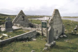 a roofless ruin of a church situated within a surrounding graveyard