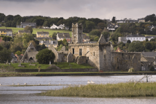 looking at the friary from across the river. The sky is turning a dusky pink, signalling evening time.