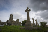 the friary lies in the background, with high crosses standing in the foreground, almost looming because the shot is taken from below.