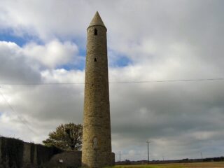 The thin round tower piercing the clouded sky