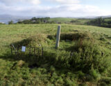 view of the pillar stone with the surrounding hills and sea just visible in the background