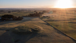 sun setting over the field mounds